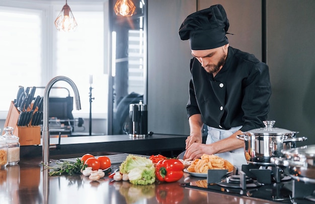 Professional young chef cook in uniform working on the kitchen