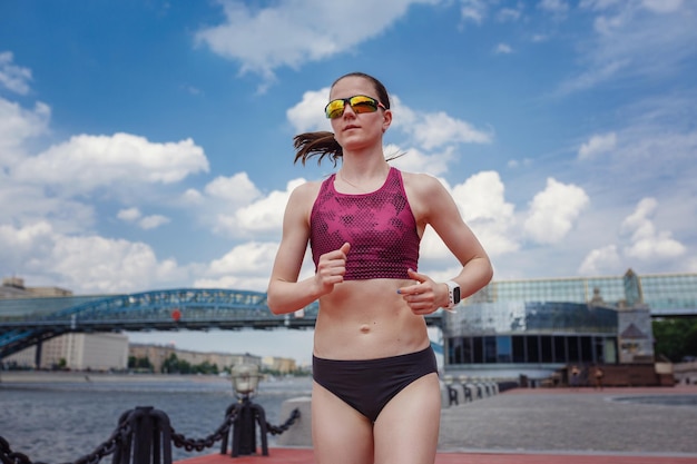 Professional young female runner player running in park for training personal speed and explosive force at holiday weekend The idea and concept of healthy lifestyle in a big city Moscow Gorky Park
