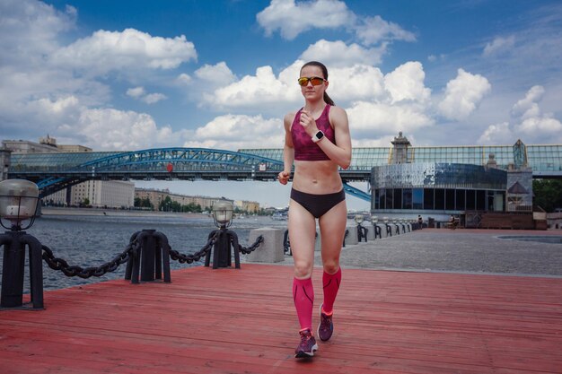 休日の週末に個人的なスピードと爆発力を訓練するために公園で走っているプロの若い女性ランナープレーヤー大都市モスクワゴーリキイ公園での健康的なライフスタイルのアイデアとコンセプト