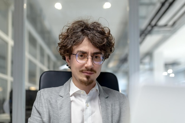 Professional young male executive working attentively at his desk in a welllit office space exuding