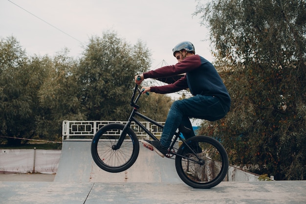 Photo professional young sportsman cyclist with bmx bike at skatepark