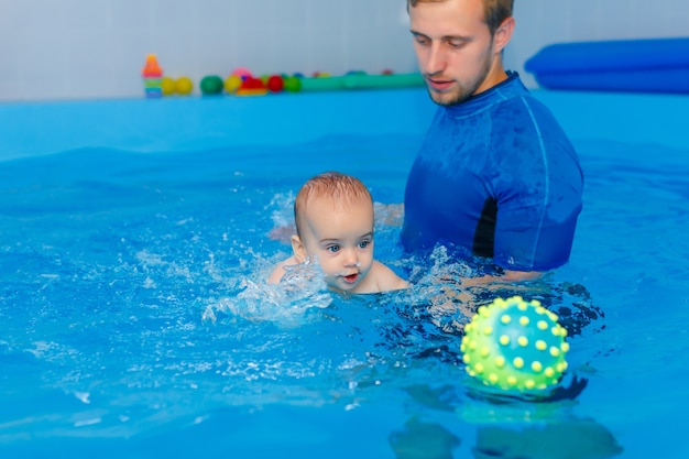 プールの天候で泳ぐ準備ができている青い帽子のプロの若い水泳選手。