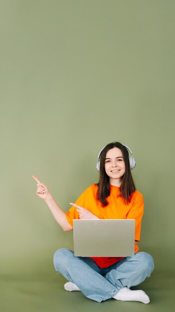 Professional young woman working with a modern laptop gadget and confidently pointing with two fing