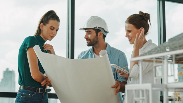 Professioneel architecten-ingenieur team praten delen brainstorming over ontwerp terwijl manager houdt bij projectplan jonge architect houdt plan terwijl manager luisteren en wijzen op plan tracery.