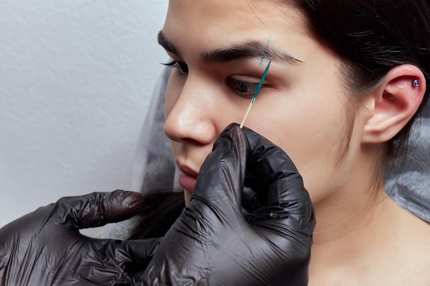 Professioneel het plaatsen van het juweel van piercing op de tempel op het hoofd met bal tragus type