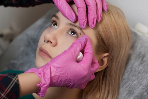 Professioneel het plaatsen van het juweel van piercing op de tempel op het hoofd met bal tragus type