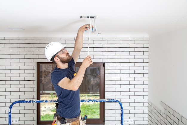 Foto professioneel in overall met gereedschap op de achtergrond van de reparatielocatie. home renovatie concept.