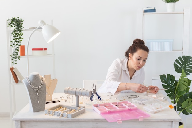 Professionele accessoires ontwerper handgemaakte sieraden maken in werkplaats. mode, creativiteit en handgemaakt concept.