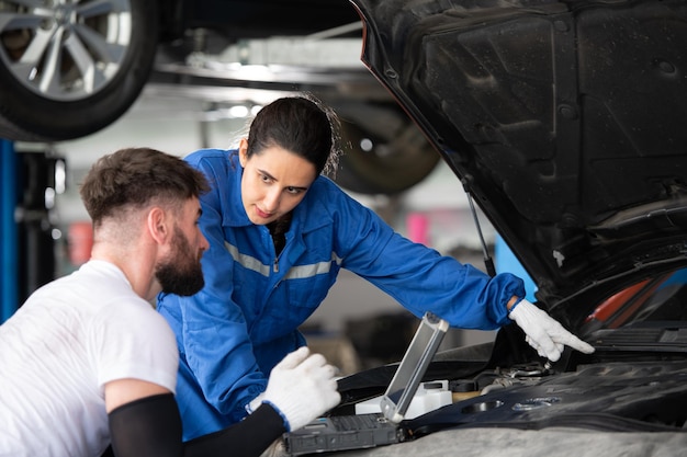 Professionele auto-mechanicus man en vrouw werken samen in een auto-reparatiewinkel