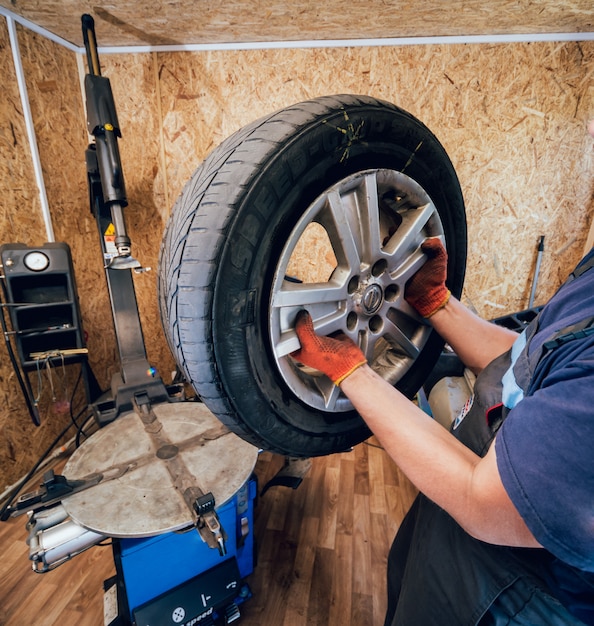 Professionele automonteur vervangt band op wiel.