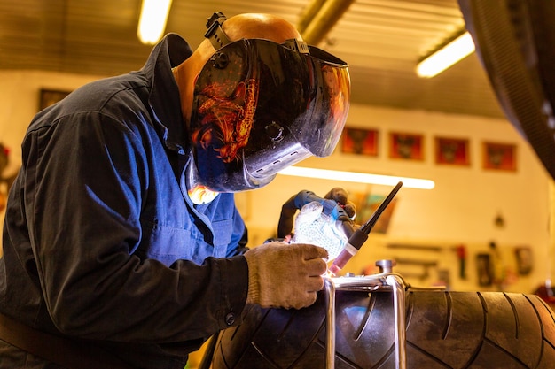 Professionele automonteur werkzaam in autoreparatieservice op argongassnijmachine