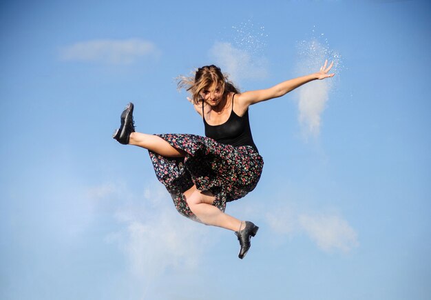 Professionele balletdanser springen met rode stof op zonsondergang zon.