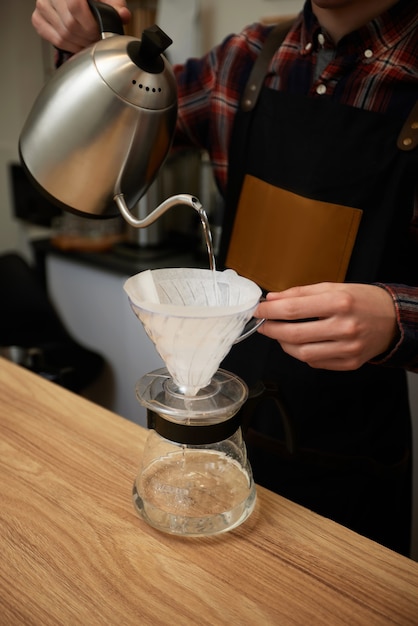 Professionele barista-man die koffie maakt in de coffeeshop