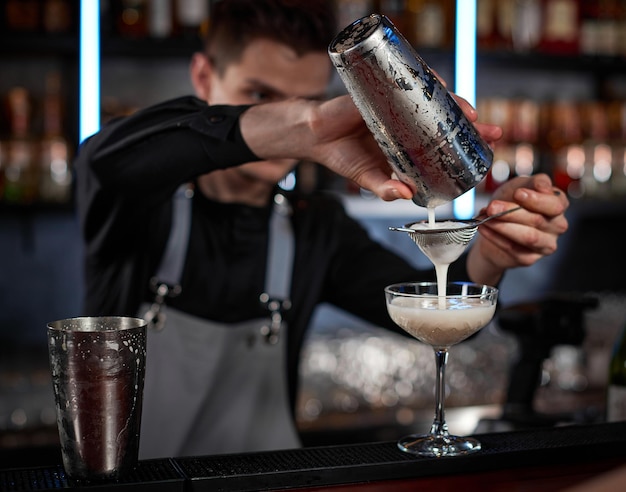 Professionele barman maakt cocktails in een nachtclub.
