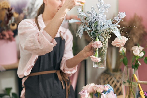 Professionele bloemist jonge vrouw die boeketten bij bloemenwinkel doet