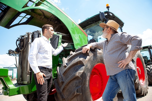 Professionele boer met een moderne tractor combineert op een veld in zonlicht op het werk