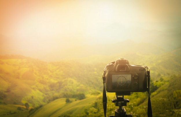 Professionele camera / camera op statief met uitzicht op de natuur in de bergen op de achtergrond - foto's maken natuur fotograferen