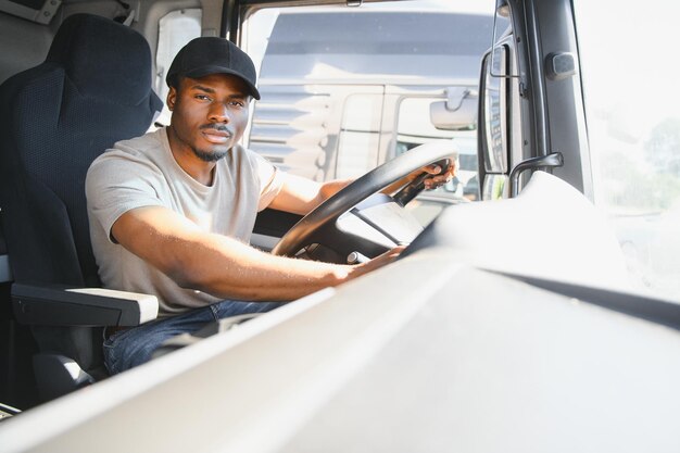 Professionele chauffeur zit in de cabine van de vrachtwagen en rijdt