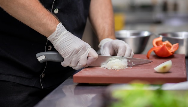 Professionele chef-kok in uniform verse groenten bereiden op snijplank in restaurantkeuken Culinair concept