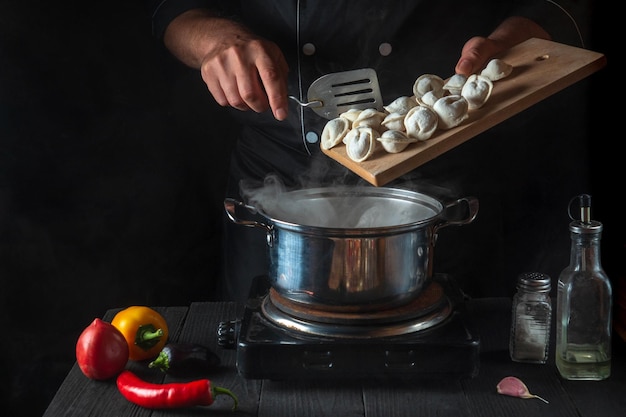 Professionele chef-kok kookt vleesknoedels in een pan in de restaurantkeuken