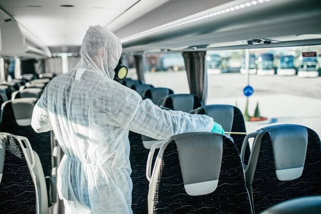 Professionele chemische reiniging van busstoelen. Busdesinfectie. Verdelger in werkkleding.