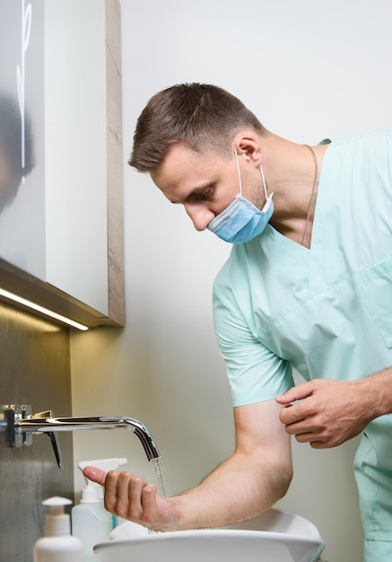 Professionele chirurg wast zijn handen in de kliniek vóór de operatie van de operatie