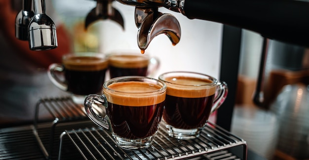 Professionele espressomachine tijdens het bereiden van twee espresso's geschoten in een coffeeshop Close-up espresso