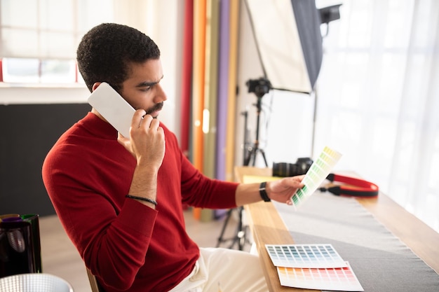 Professionele fotograaf heeft een telefoongesprek met de klant die het kleurconcept bespreekt