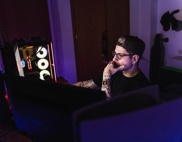 Professionele gamer kijkt naar esports in zijn kamer met roze ledverlichting