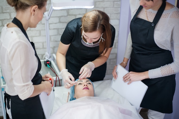 Professionele huidverzorging therapie. Vrouwelijke schoonheidsspecialisten werken met klant in moderne kliniek.