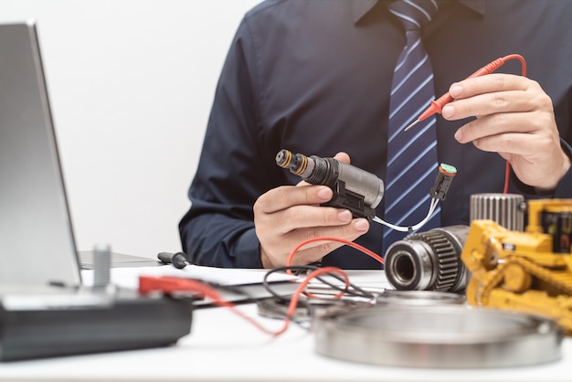 Foto professionele ingenieur inspec solenoïdeklep voor tijdens werkdag in kantoor, reparatie onderhoud zware machines concept