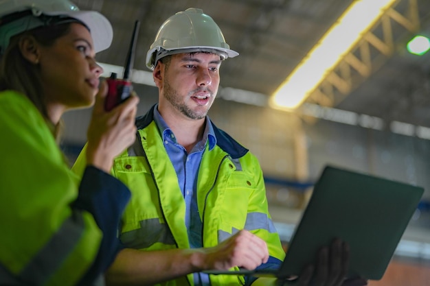 Professionele ingenieurswerkers lopen en checken in de magazijnfabriek