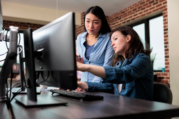 Professionele kantoormedewerkers wijzen op de verkeerde blauwdruk van het project tijdens het gebruik van de werkcomputer. Creatieve ontwerpers ontwikkelen digitale kunst op pc terwijl ze discussiëren over 3D-technologie.