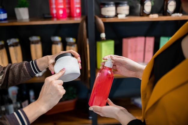 Professionele kapper die verzorgingsproducten voor haarverlenging aanbiedt aan de klant in de schoonheidssalon