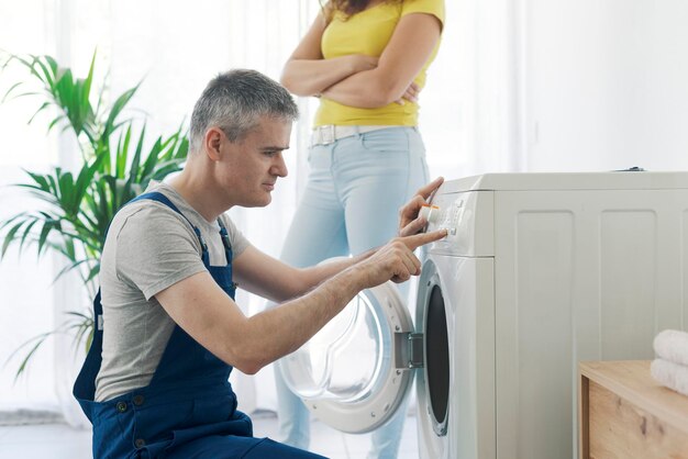 Professionele loodgieter die een wasmachine controleert