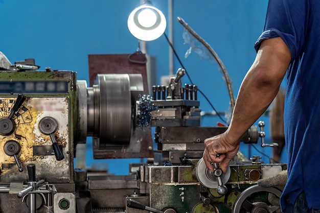 Professionele machinist hand werken met draaibanken machine in metaalbewerking fabriek