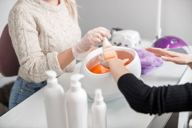 Professionele manicure meester doet nagels voor cliënt in de schoonheidssalon