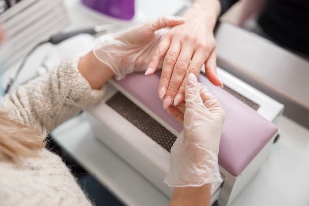 Professionele manicure meester doet nagels voor cliënt in de schoonheidssalon