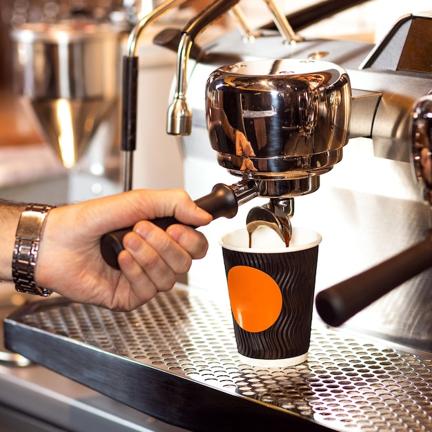 Foto professionele mannelijke barista die koffie maakt close-up