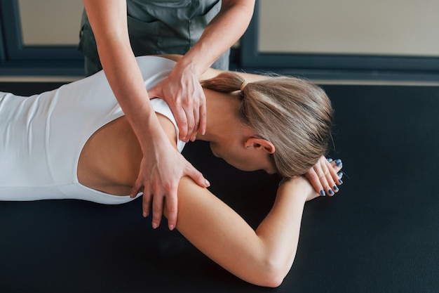 Professionele massage Vrouw is in gezondheidscentrum en krijgt hulp van dokter