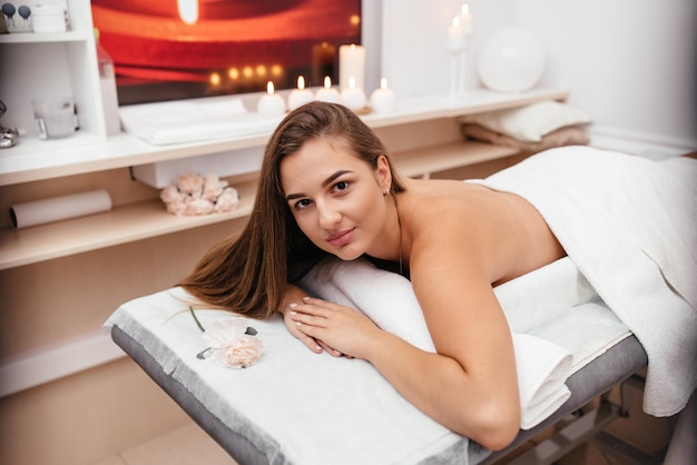 Professionele masseur die therapeutische massage doet Vrouw geniet van massage in haar huis Jonge vrouw krijgt ontspannende lichaamsmassage