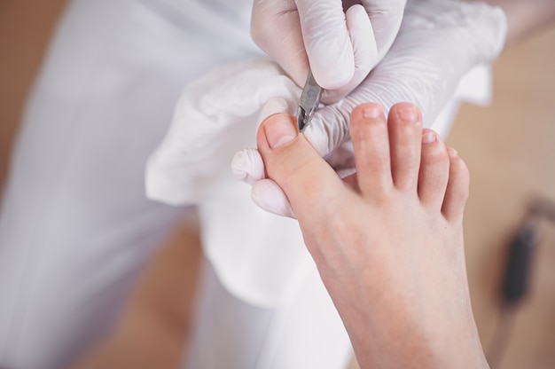 Professionele medische pedicure procedure close-up met nagelknipper