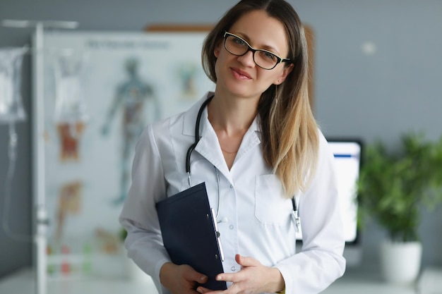 Professionele medische werker poseren met klembord in kliniek