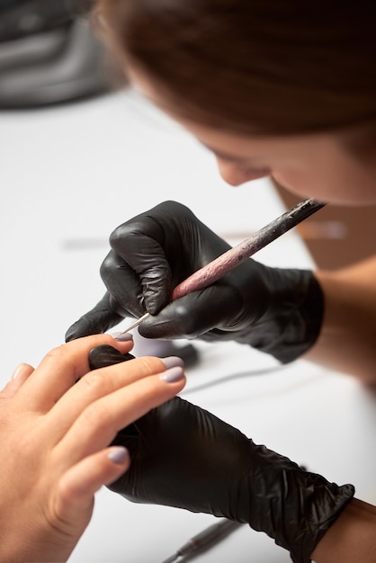 Professionele meester manicure bezig met de vingernagels van de klant