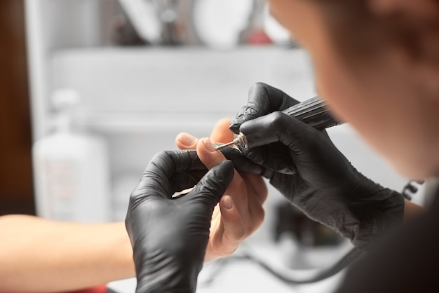 Foto professionele meester manicure bezig met de vingernagels van de klant