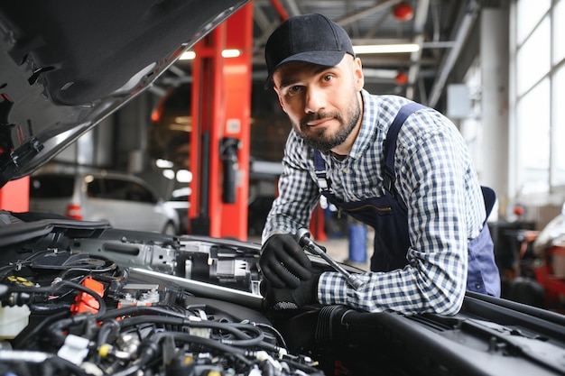 Professionele monteur werkt aan een auto in een autoservice