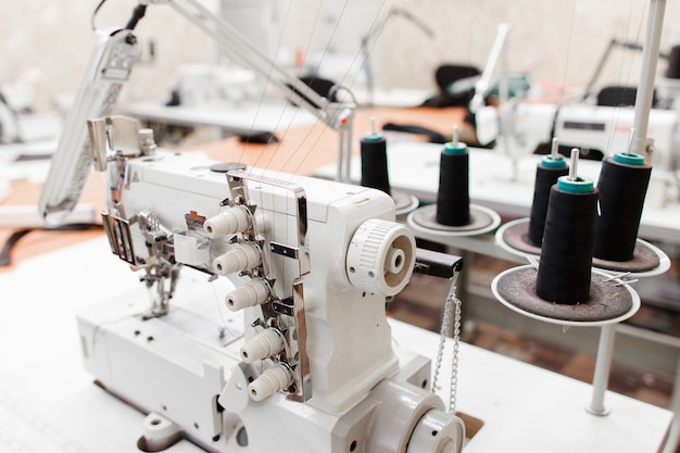 Professionele overlock naaimachine met zwarte draad in werkplaats.