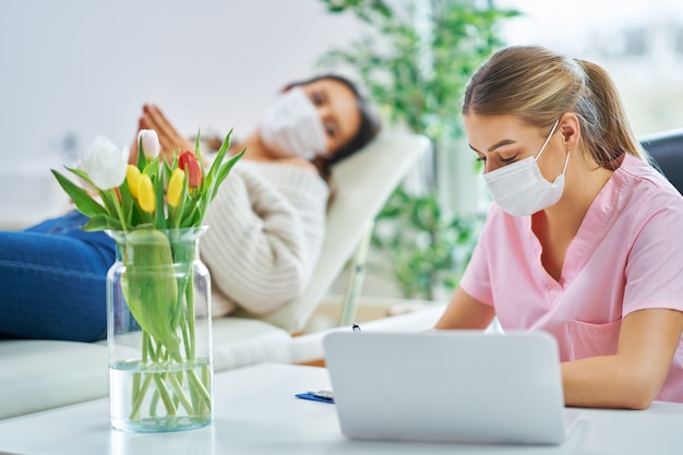 professionele psychiater die haar patiënt raadpleegt en aantekeningen maakt, beide in maskers