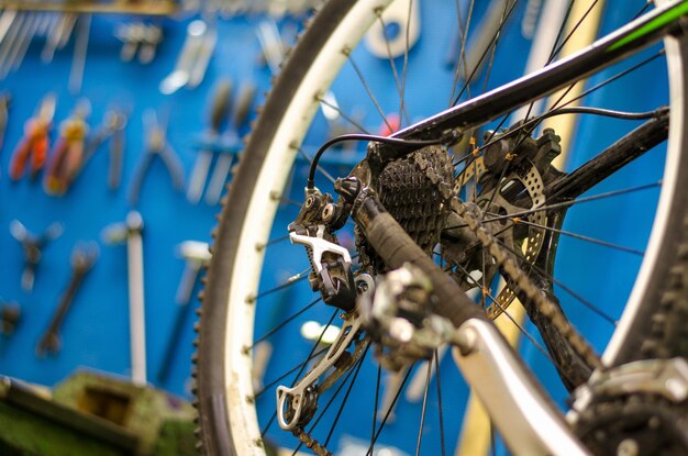 Professionele reparatie van mountainbikes Voorbereiding voor de wedstrijd Fiets op de achtergrond van het bord met gereedschap Achterwiel close-up