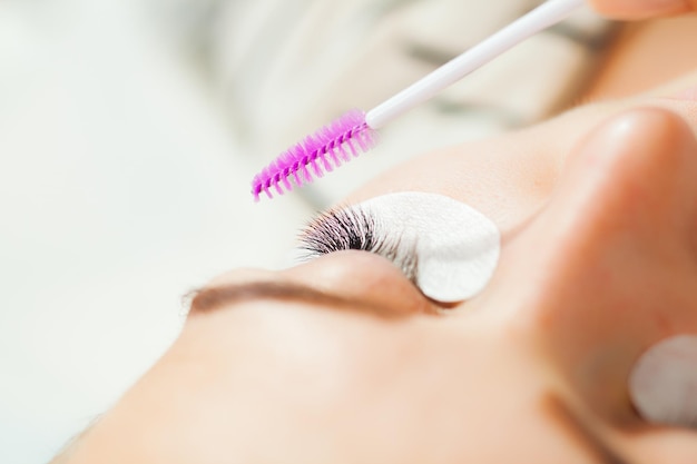 Foto professionele schoonheidsspecialist die wimperverlengingsprocedure doet in schoonheidssalon